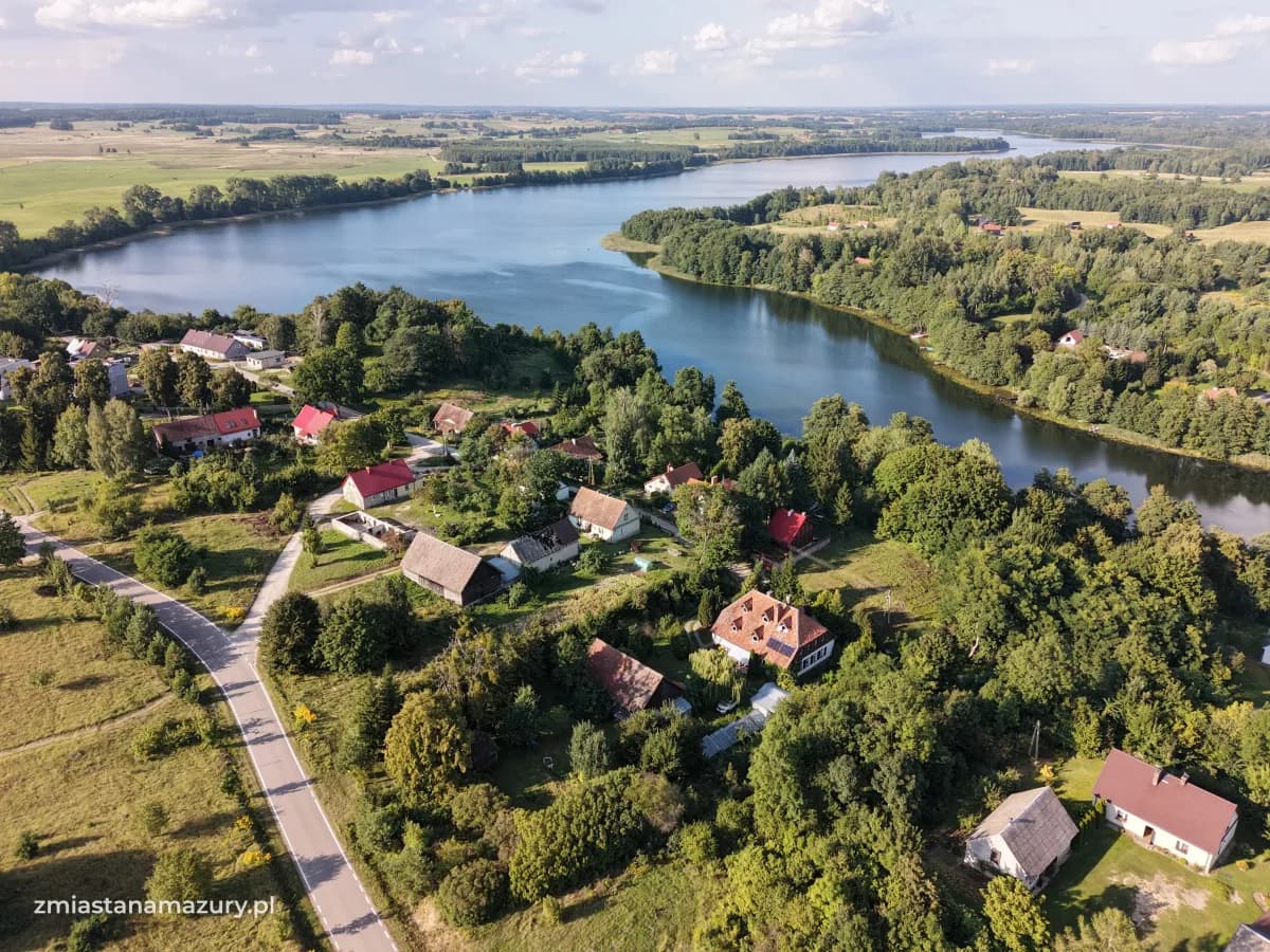 Widok z drona na jezioro Buwełno, zabudowę i krajobraz w Cierzpiętach